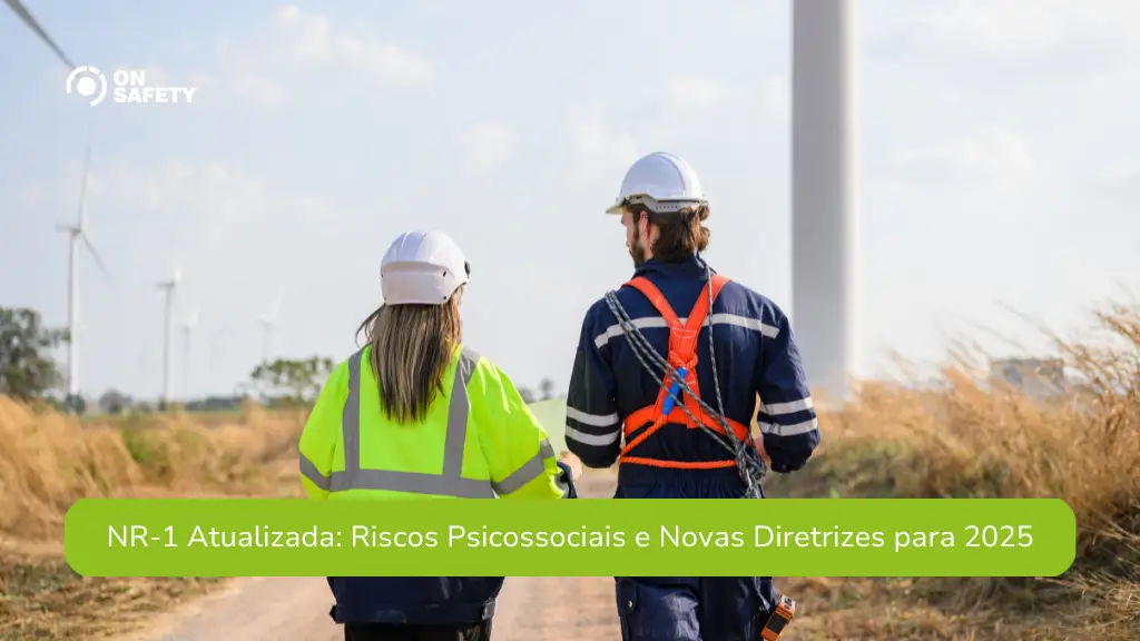 Dois profissionais de segurança do trabalho caminhando em uma área externa, próxima a turbinas eólicas. Ambos usam capacetes de proteção, e um deles veste colete refletivo enquanto o outro está com um cinto de segurança. Na parte inferior da imagem, lê-se: "NR-1 Atualizada: Riscos Psicossociais e Novas Diretrizes para 2025".