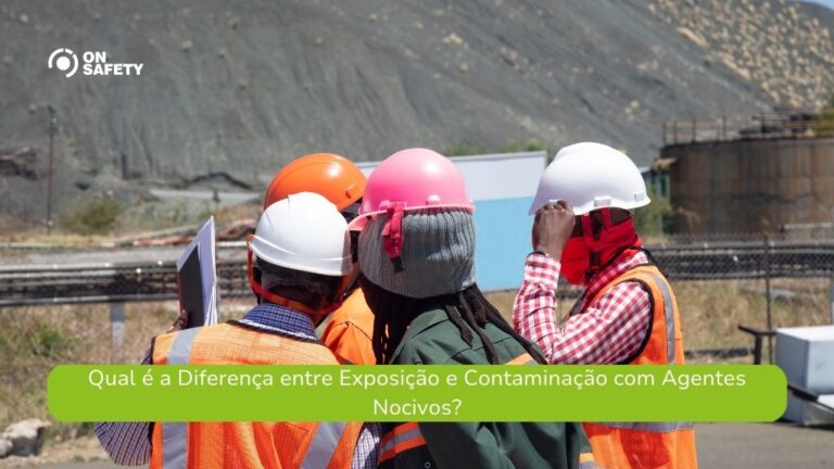 Quatro profissionais usando EPIs, incluindo capacetes e coletes refletivos, estão reunidos em um ambiente externo, provavelmente uma área industrial ou de mineração. Eles analisam documentos e observam o local ao redor. Ao fundo, há um grande monte de terra ou escória e estruturas industriais. O logo da OnSafety está no canto superior esquerdo e, na parte inferior, uma faixa verde apresenta a pergunta: "Qual é a Diferença entre Exposição e Contaminação com Agentes Nocivos?"