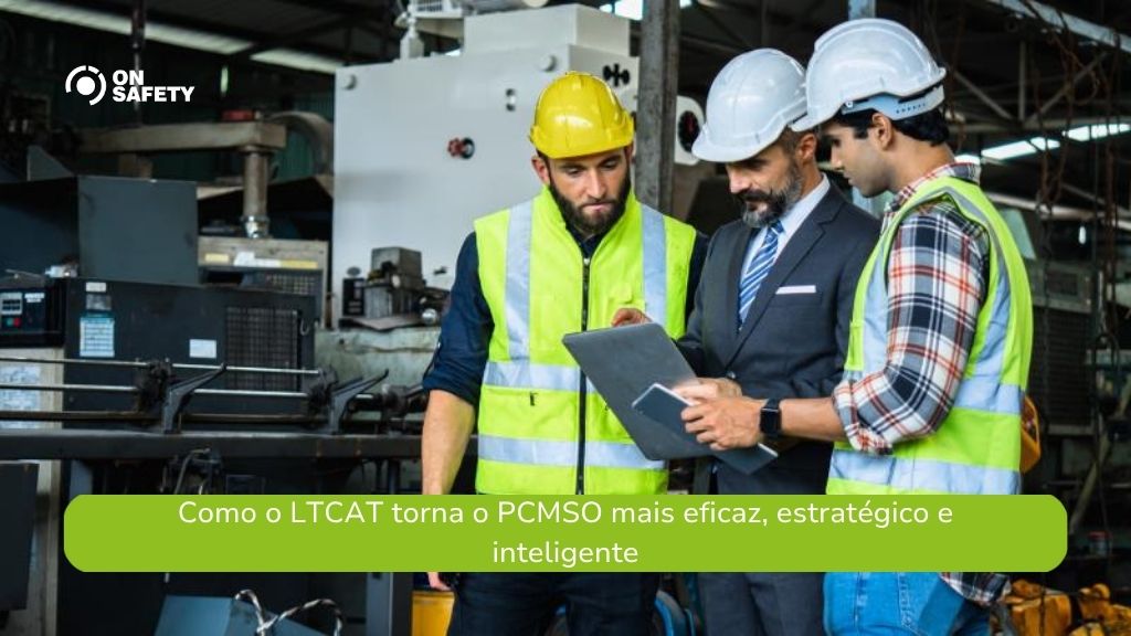 Três homens usando equipamentos de proteção, incluindo coletes refletivos e capacetes, estão em uma fábrica. Um deles segura um tablet enquanto os outros observam, indicando uma análise técnica ou reunião de segurança. No canto superior esquerdo da imagem está o logo da OnSafety. Na parte inferior, uma faixa verde exibe o texto: “Como o LTCAT torna o PCMSO mais eficaz, estratégico e inteligente”.