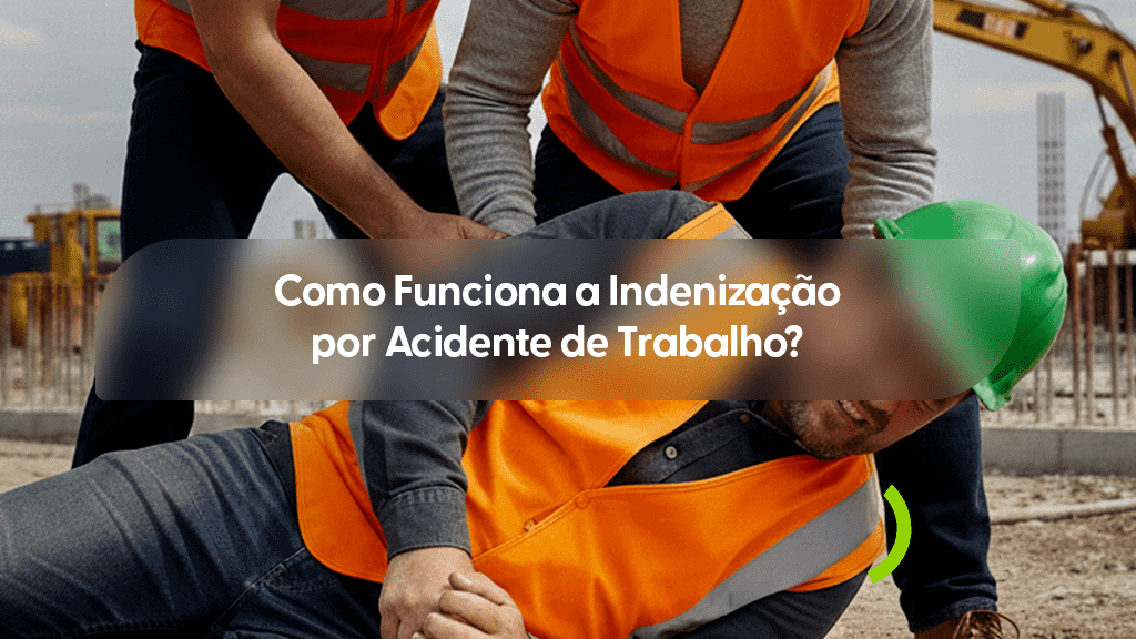 Imagem em um canteiro de obras mostrando um trabalhador caído no chão de terra após um acidente, sendo amparado por dois colegas que vestem coletes refletivos laranja. O trabalhador acidentado usa um colete laranja sobre uma camisa cinza e um capacete de segurança verde, que está levemente inclinado. Um detalhe em arco verde estilizado aparece próximo ao seu ombro direito. No centro, uma faixa horizontal escura e transparente destaca o título em branco: "Como Funciona a Indenização por Acidente de Trabalho?".