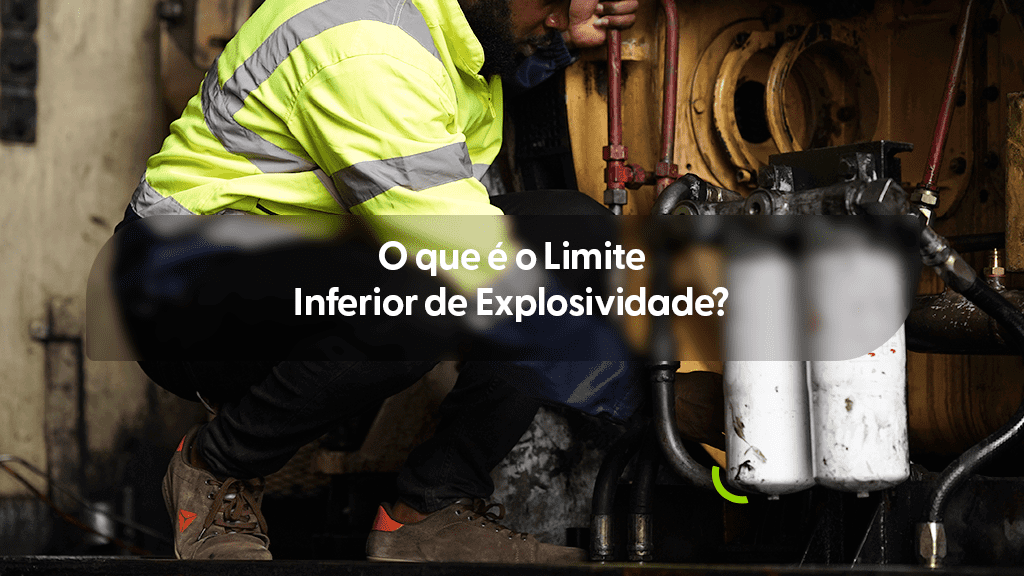 Foto colorida de um profissional vestindo jaqueta de alta visibilidade amarela, agachado enquanto faz a manutenção de um maquinário industrial. No centro, uma faixa escura traz o texto em branco: "O que é o Limite Inferior de Explosividade?".